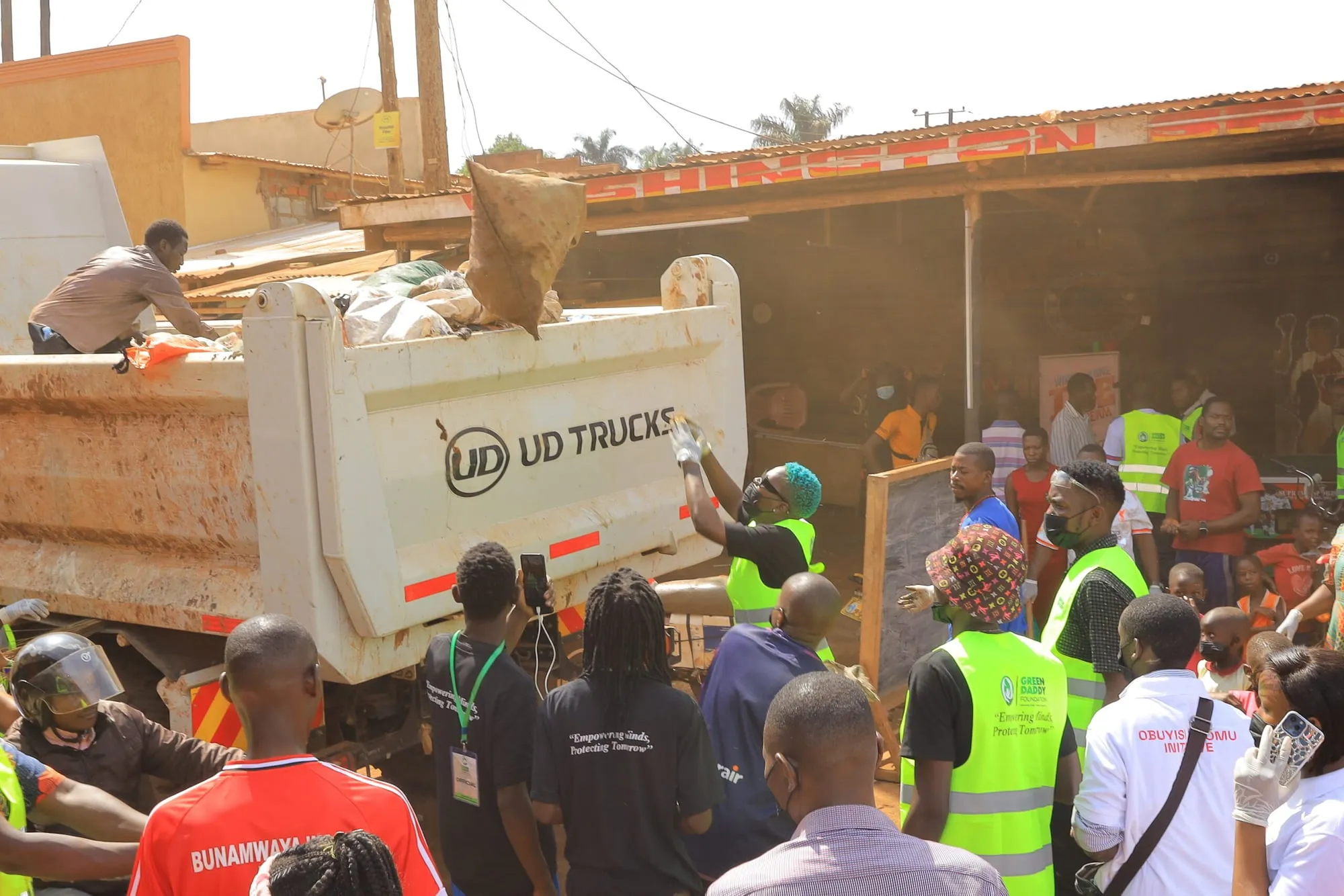 Volunteers loading waste onto a truck during a community clean-up