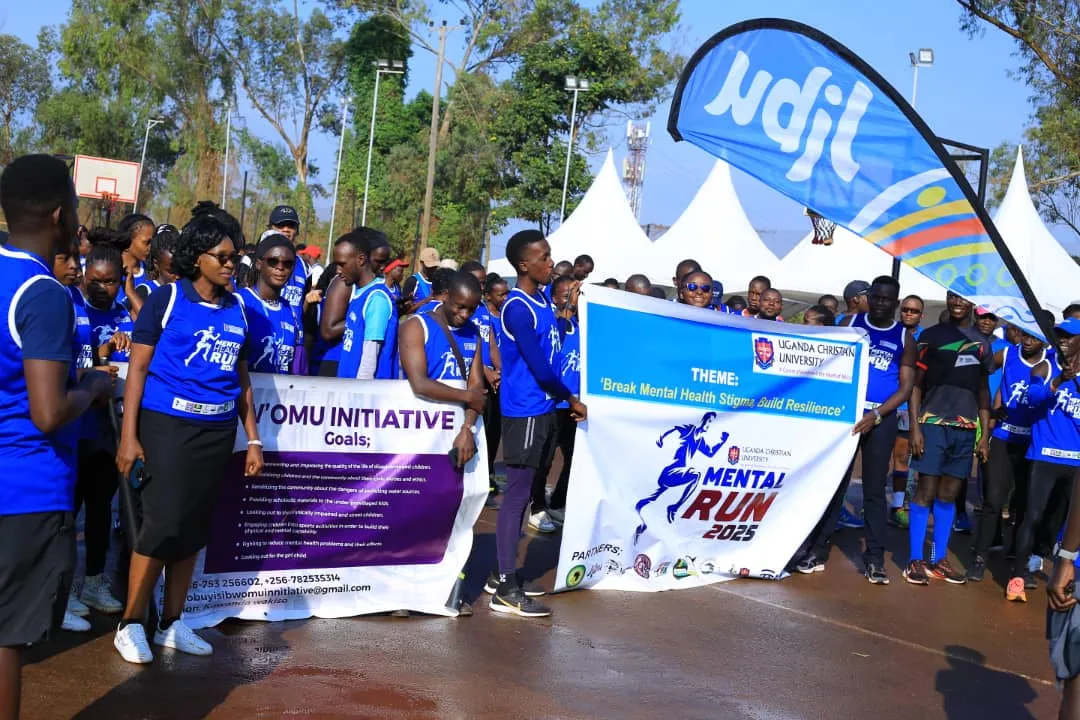 Runners and volunteers holding Obuyisi bw'Omu Initiative and Mental Health Run 2025 banners