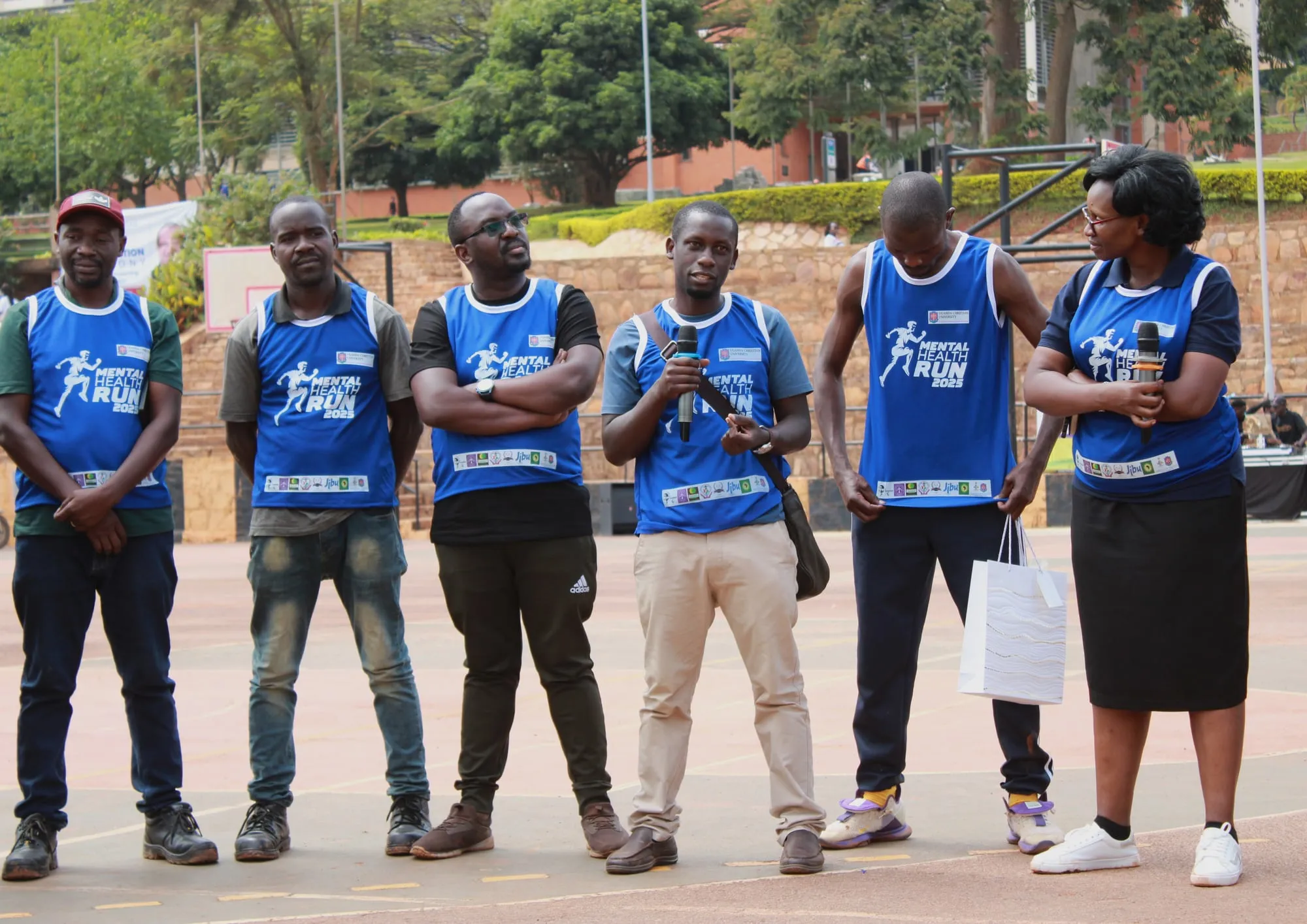 Obuyisi bw'Omu Initiative team members in blue Mental Health Run shirts